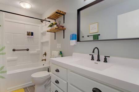 uma casa de banho branca com um lavatório e um WC em Cozy Updated Home W Rec Room & Large Backyard em North Canton