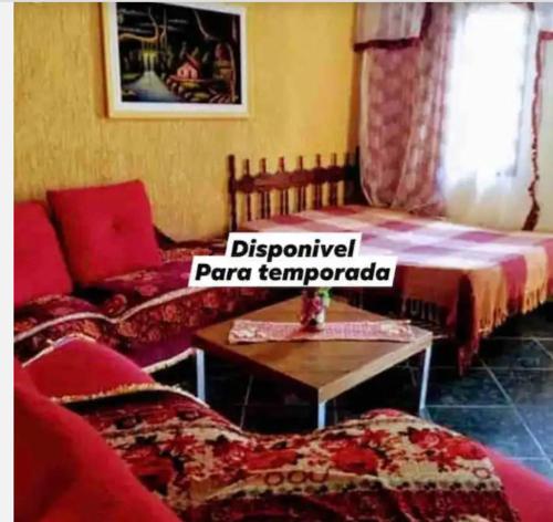 Sala de estar con 2 camas y mesa en recanto Gonzales, en Sarapuí