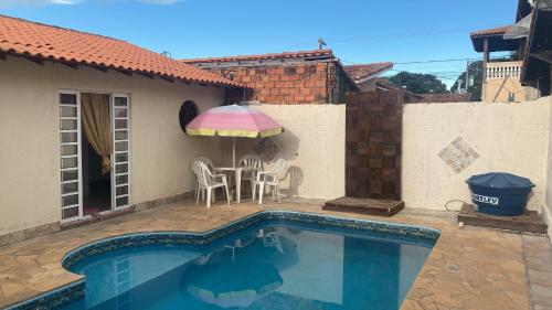 - Piscina con mesa y sombrilla en recanto Gonzales, en Sarapuí