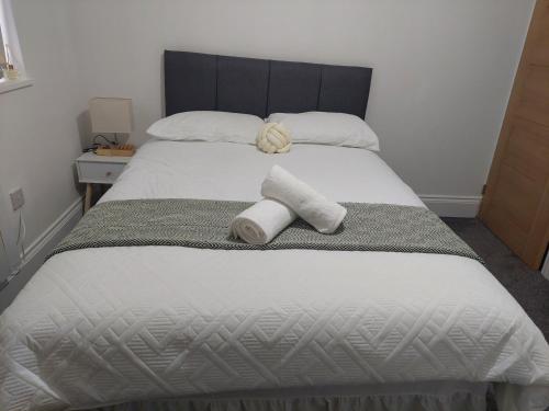 a bedroom with a bed with two towels on it at Guest Apartments in Redditch