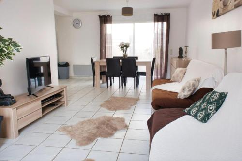 ein Wohnzimmer mit einem Sofa, einem TV und einem Tisch in der Unterkunft Beautiful 120m house in Saint-Laurent-de-la-Salanque