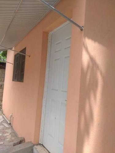 a white garage door on the side of a house at Fay guess house in Spanish Town
