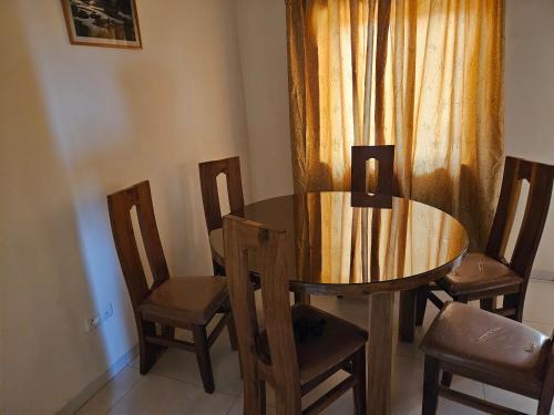 ein Esszimmer mit einem Holztisch und Stühlen in der Unterkunft Hébergement VIP in Ouagadougou