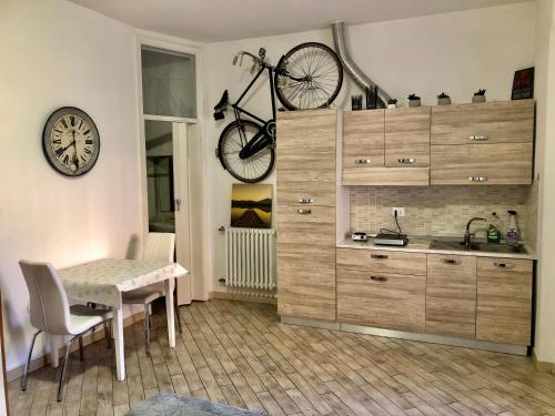 a kitchen with a table and a bike on the wall at Il volto del lago - Rooms&Apartments in San Felice del Benaco
