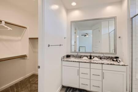 a white bathroom with a sink and a mirror at NEW - 5BR Home 20 min from Phoenix - AT in Avondale