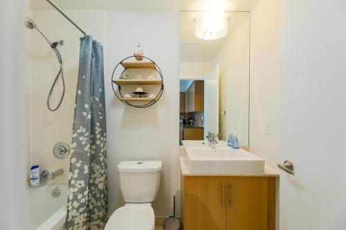 een badkamer met een wastafel, een toilet en een douche bij Skyline Elegance Condo in Toronto