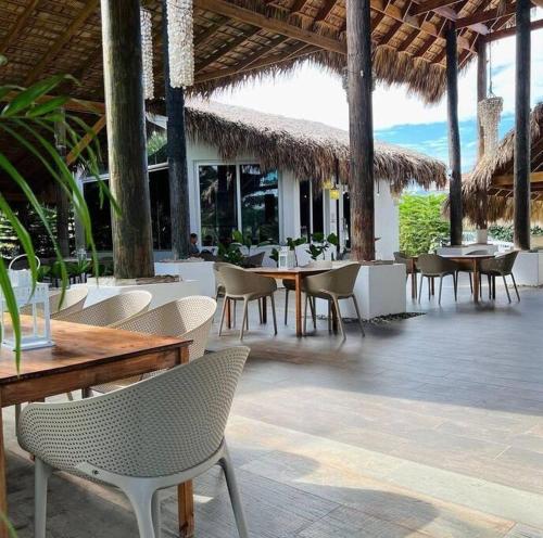 ein Restaurant mit Tischen, Stühlen, Tischen und Stühlen in der Unterkunft Apartamento en Playa Palenque in Puerto Palenque