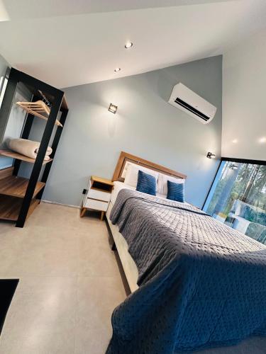 a bedroom with a large bed and a large window at Cabana Sabá in Ibiúna