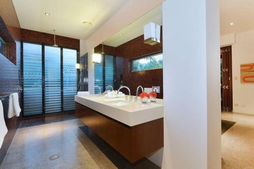 baño con lavabo grande y espejo grande en 6 Beachfront Mirage - Luxury 4 Bedroom Home, en Port Douglas