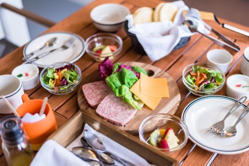 a wooden table topped with plates and bowls of food at Mt Fuji View Villa Fujino Kirameki Fujigotemba in Gotemba