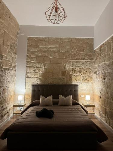 a bedroom with a large bed with a stone wall at La Maison di Serena in Bari