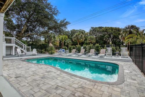a swimming pool with chairs and a fence at Edgewater 5 in Isle of Palms
