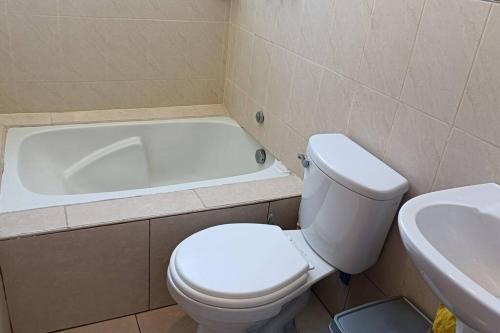 een badkamer met een toilet en een bad bij Qori Garden Apartment in Cuzco