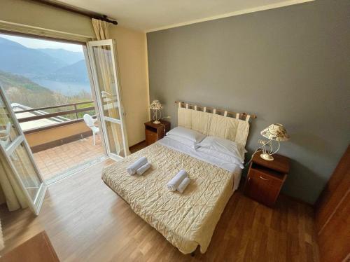 a bedroom with a bed with a view of a balcony at Hotel Ristorante La Sorgente in Plesio