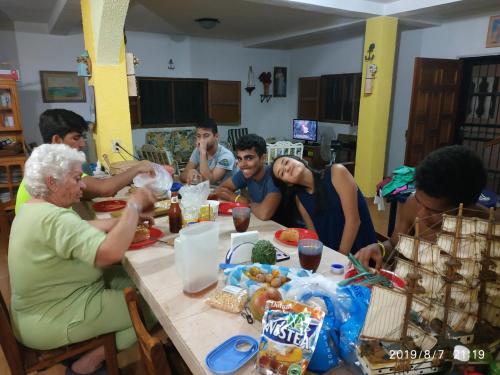 un grupo de personas sentadas alrededor de una mesa comiendo en Tú Casa de playa La Milagrosa en Boca de Uchire
