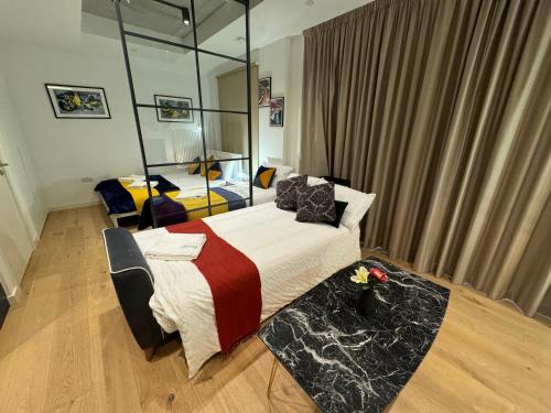 a bedroom with two beds and a mirror at London Luxury flat with Balcony, O2 Arena, Excel, Canary Wharf, Station in London