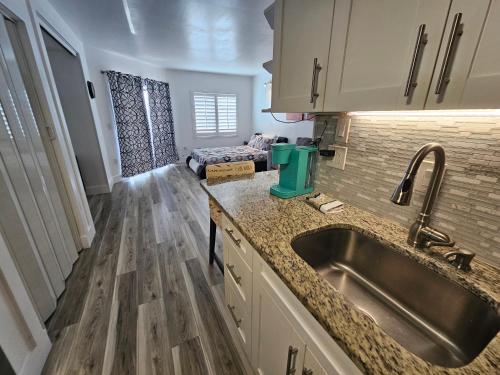 a kitchen with a sink and a living room at Cozy Condo on International Dr. Near Universal Studios in Orlando