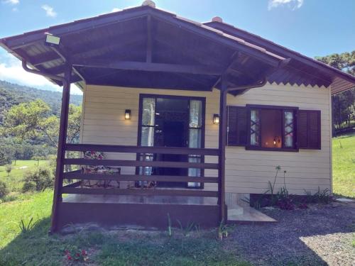 a tiny house with awning and a porch at CASAS DE CAMPO MOZZAFIATO in Urubici