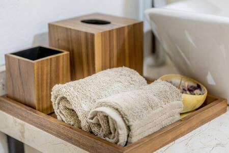 a wooden shelf with towels on a bathroom counter at Cipressi Spectacular Italian Tuscan style loft in Santeagueda