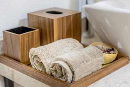 - une étagère en bois avec des serviettes sur le comptoir de la salle de bains dans l'établissement Cipressi Spectacular Italian Tuscan style loft, à Santeagueda
