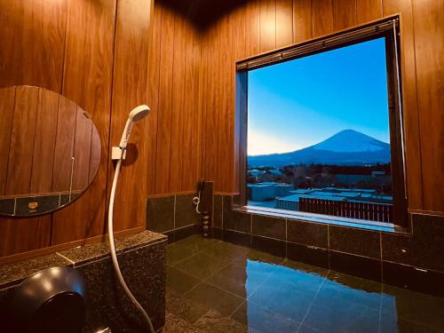 a bathroom with a shower and a window with a view at Fujino Kirameki Fujigotemba in Gotemba