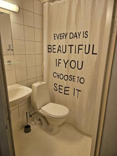 a bathroom with a toilet and a shower curtain at Motell Lier in Lier