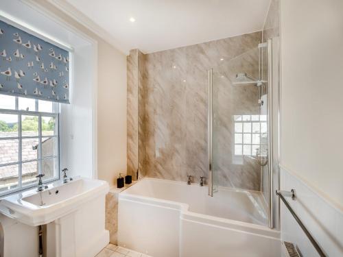 a bathroom with a tub and a sink and a shower at Cartmel Place in Cartmel