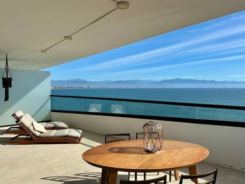 a table and chairs on a balcony with a view of the ocean at Departamento Bucerías con Vista al Mar - Narval Norte in Bucerías