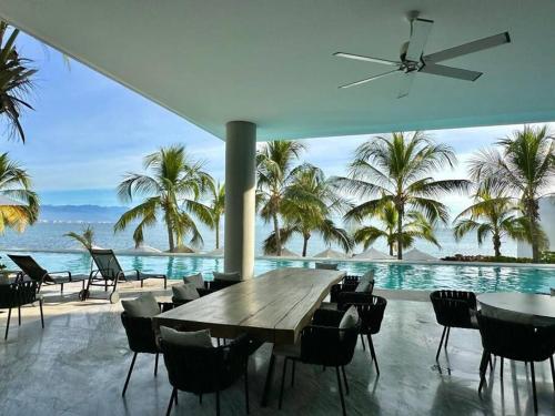 a dining area with a table and chairs and the ocean at Departamento Bucerías con Vista al Mar - Narval Norte in Bucerías