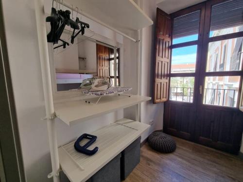 a room with a shelf with a large mirror at Exclusividad a Pie de la Torre de la Catedral in Granada