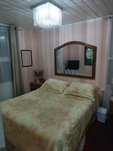 um quarto com uma cama grande e um espelho em Marynes em Pucón