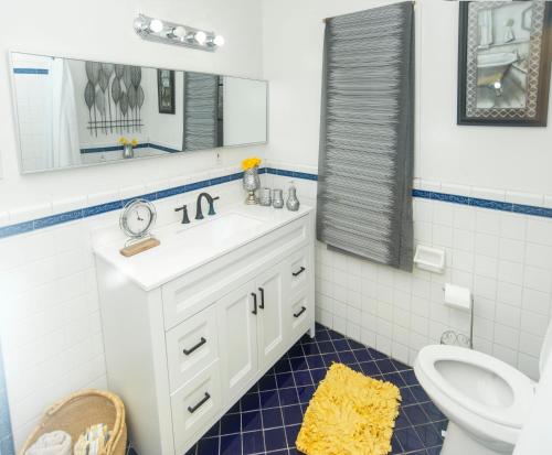 a bathroom with a sink and a toilet and a mirror at Manuel Y Sonia-La casa de los Angeles in Long Beach