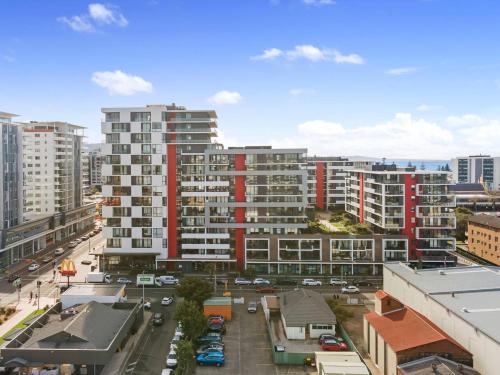 a city with tall buildings and a street with cars at Burelli Beach Escape - Breezy Seaside Charm in Wollongong