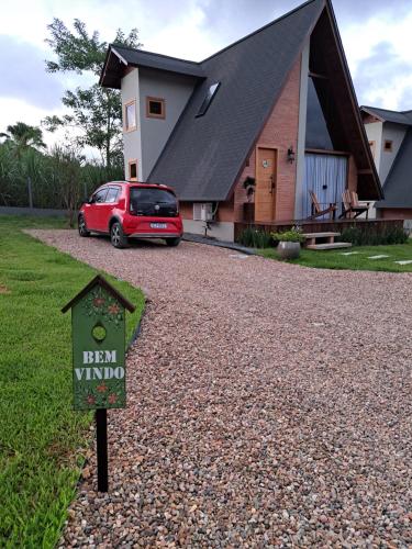 um carro vermelho estacionado em frente a uma casa em Chalé Villa Felicitá (Itália) em Pomerode