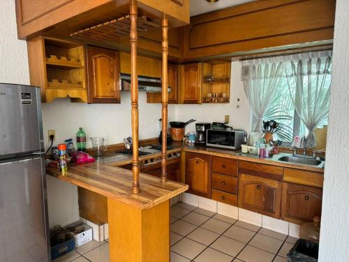 uma cozinha com armários de madeira e uma bancada em Habitación privada en casa de huespedes em Guadalajara