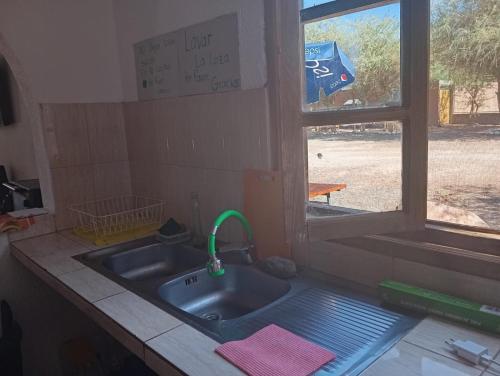 d'un évier de cuisine avec une fenêtre. dans l'établissement Hostal el rancho, à San Pedro de Atacama