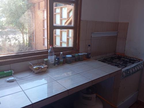 un comptoir de cuisine avec une cuisinière et une fenêtre dans l'établissement Hostal el rancho, à San Pedro de Atacama