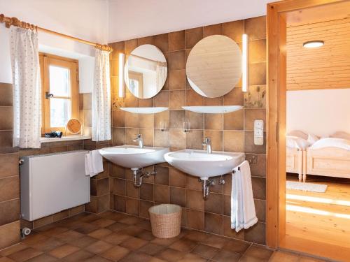 un baño con dos lavabos y dos espejos en Ferienhaus Lois & Lisl, en Schleching