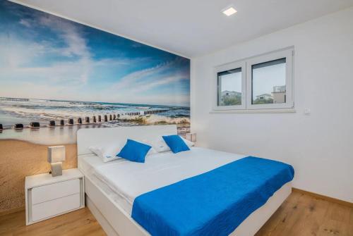 una camera con un letto e un dipinto della spiaggia di Apartments by the sea Vantacici, Krk - 21690 a Malinska