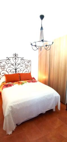 a bedroom with a white bed with a chandelier at El Mirador de Pablo, casa con patio privado in Alomartes