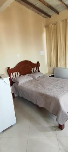 ein Schlafzimmer mit einem Bett und einem Stuhl in einem Zimmer in der Unterkunft Cantinho do Jorge in São Pedro da Aldeia