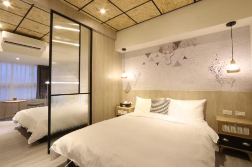 a bedroom with a white bed and a wall at MU House in Taipei