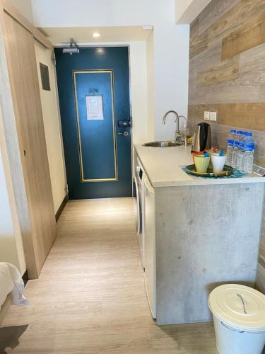 a kitchen with a blue door and a counter with a sink at MU House in Taipei