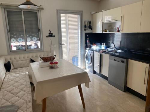 a kitchen with a table and a white table and a kitchen at Cosy Appart in Casablanca