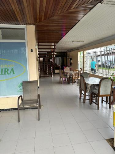 a dining area with chairs and tables and a table at Hotel Mangueira in Paramaribo