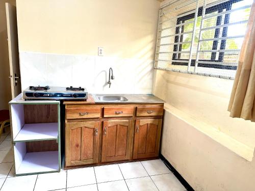 a small kitchen with a sink and a counter top at Hotel Mangueira in Paramaribo
