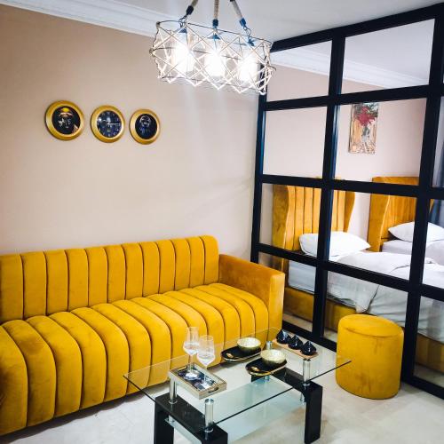 NOUVEAU Appartement au plein centre ville en face Hilton M2 في طنجة: غرفة معيشة مع أريكة صفراء وطاولة