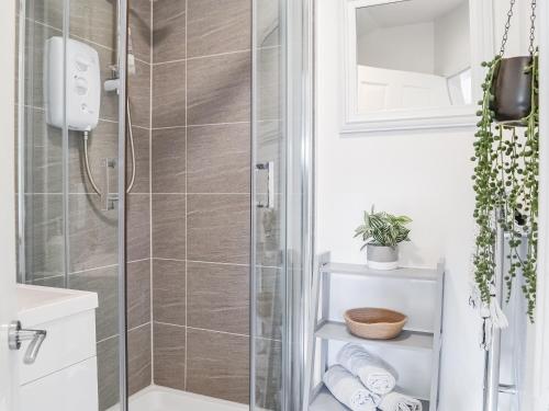 a bathroom with a shower with a glass door at The Stables in Ayr