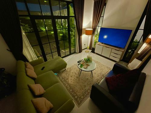 ein Wohnzimmer mit einem grünen Sofa und einem Tisch in der Unterkunft Villa Sivva Sawangan in Depok