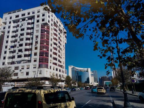 a tall white building on a city street with cars at NOUVEAU Appartement au plein centre ville en face Hilton M2 in Tangier